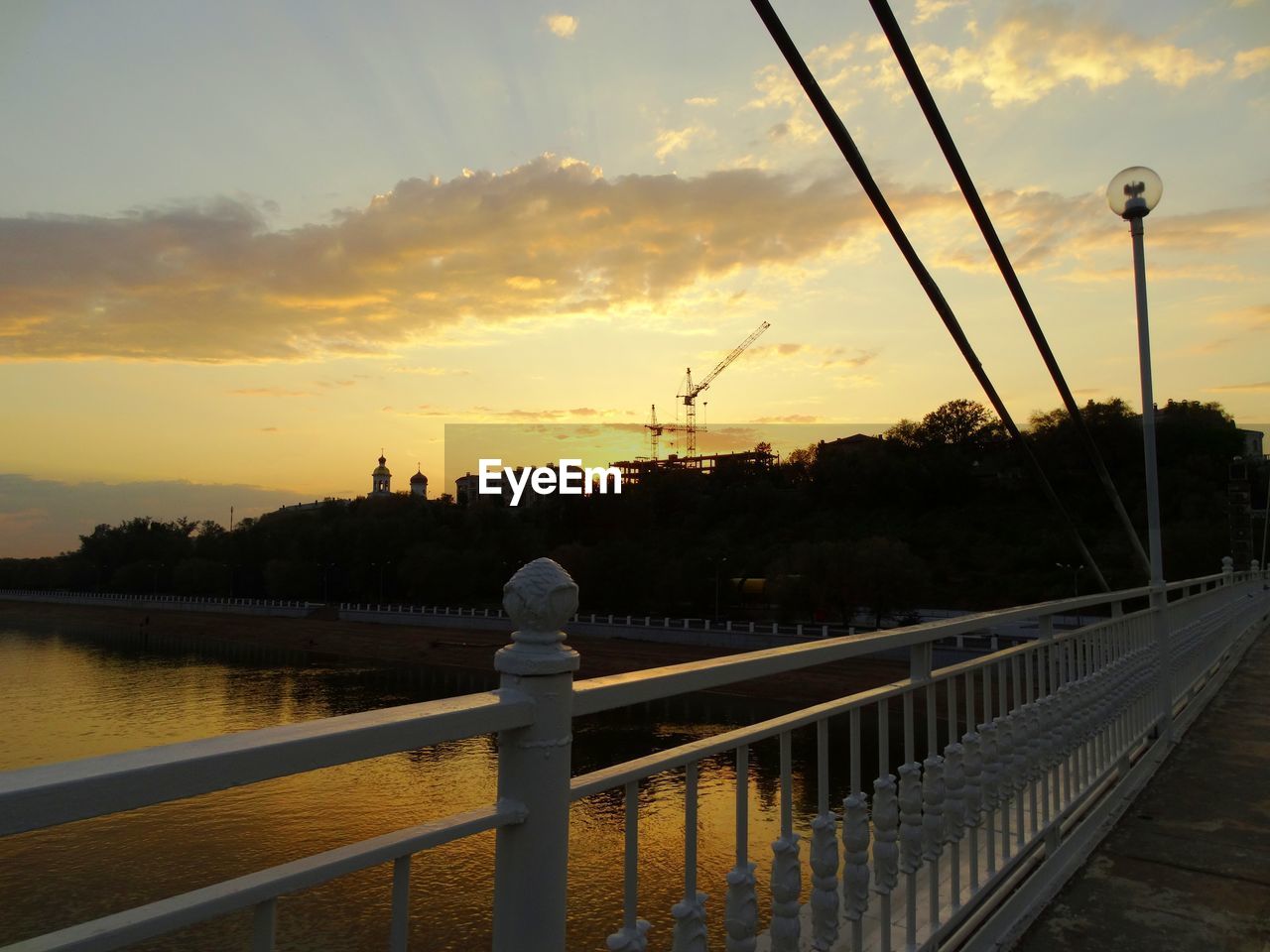 Bridge over ural river against sky during sunset