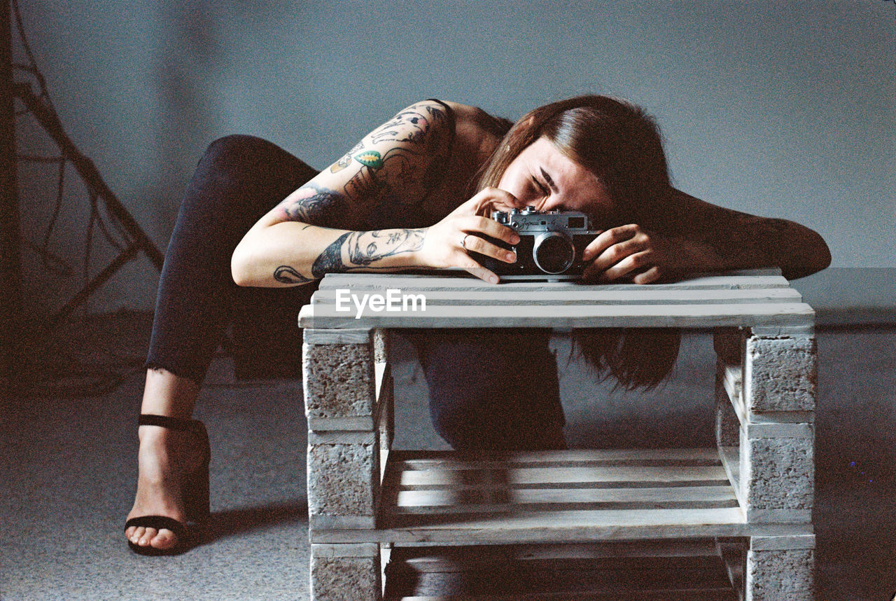 Portrait of woman photographing on table