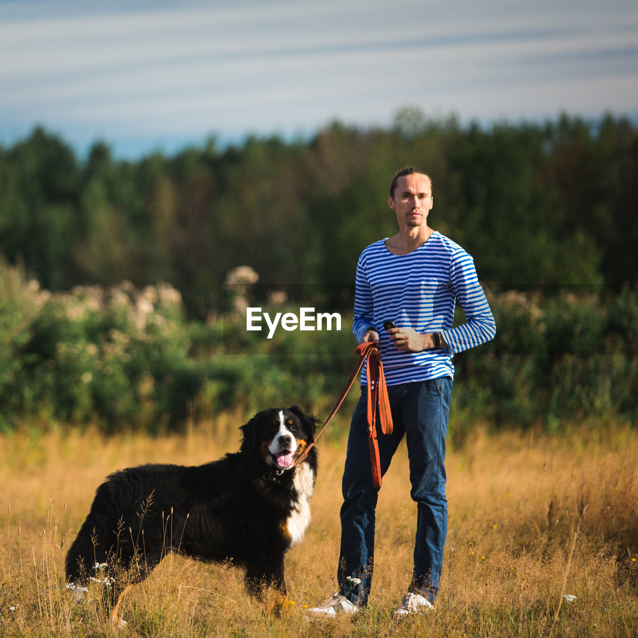 Man with dog standing on land