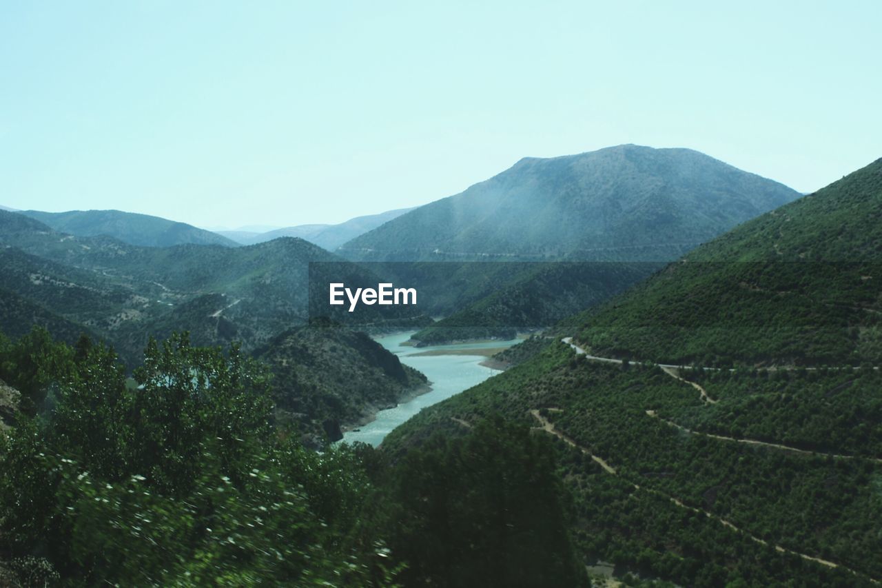 Scenic view of river and mountains against clear sky