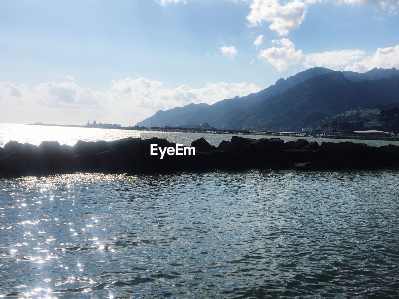 SCENIC VIEW OF SEA AGAINST MOUNTAINS