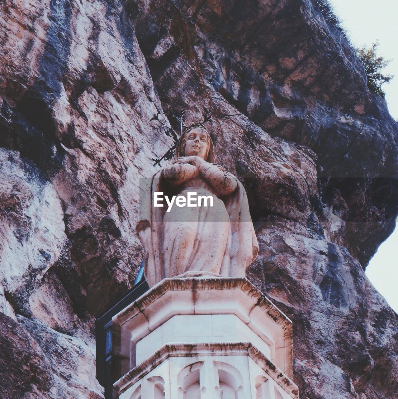 Low angle view of virgin mary statue against mountain