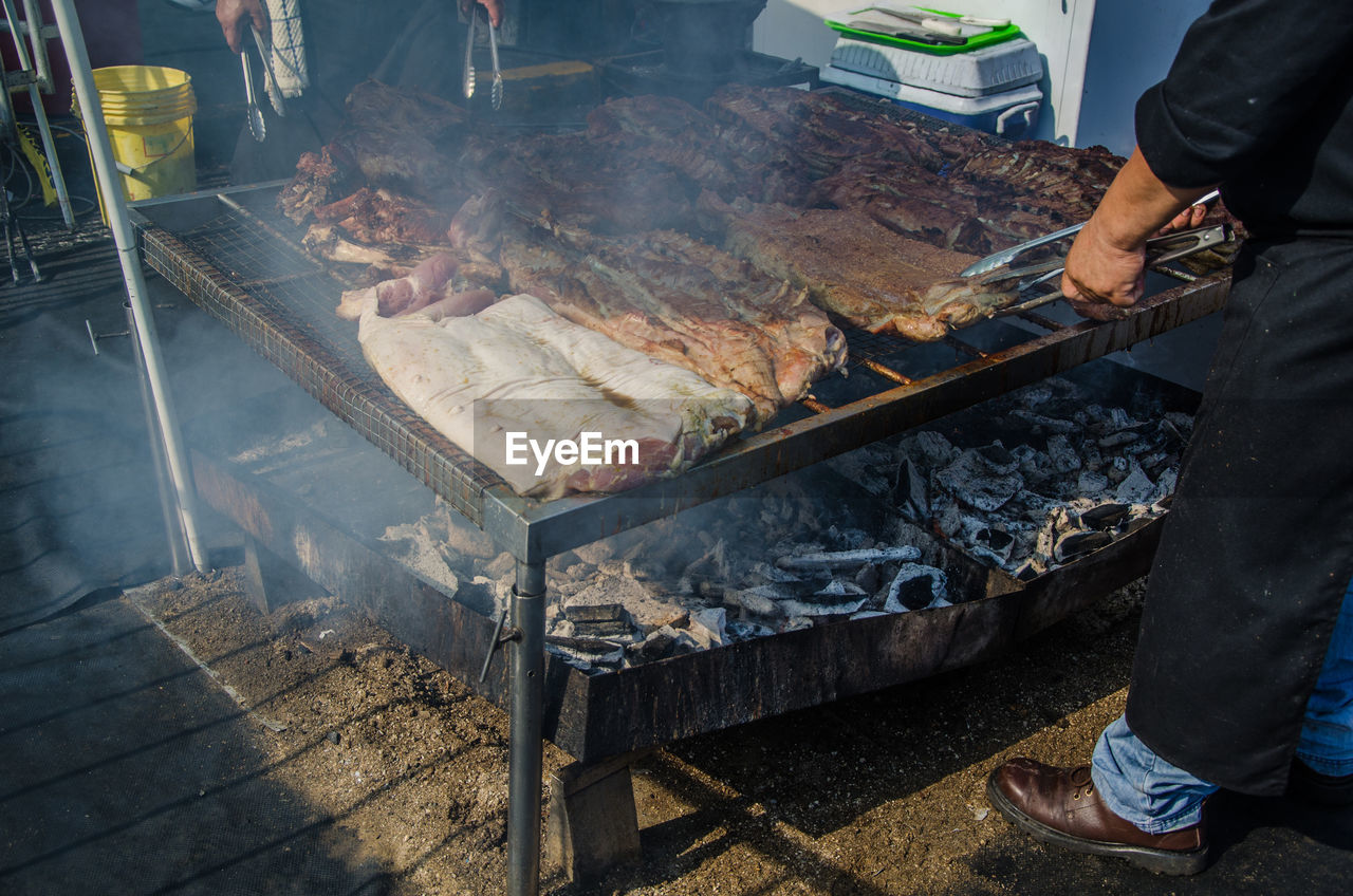 Low section of man preparing food at market stall