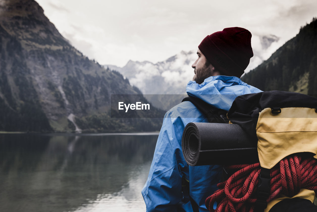 Austria, tyrol, alps, hiker standing at mountain lake