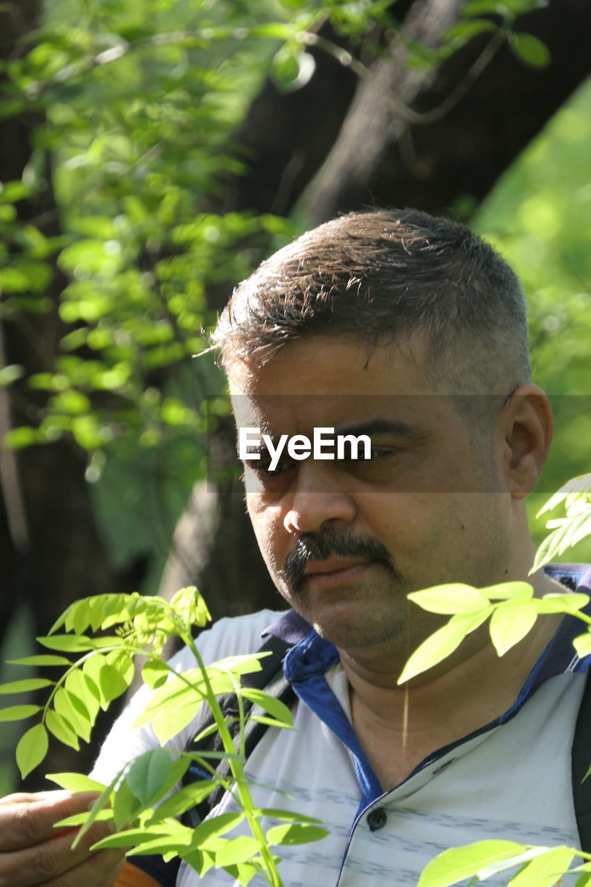 PORTRAIT OF MAN WITH PLANT