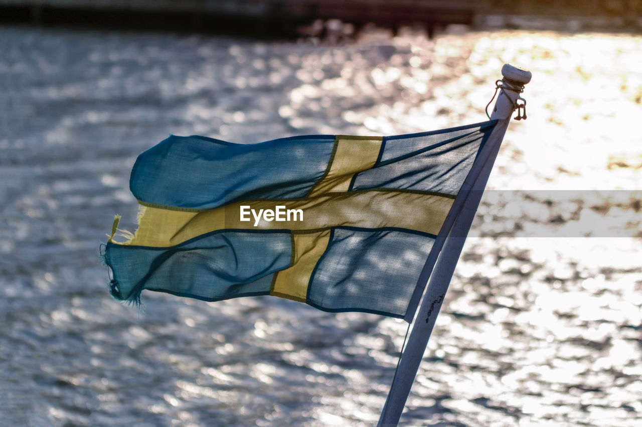 Close-up of worn out swedish flag on small boat