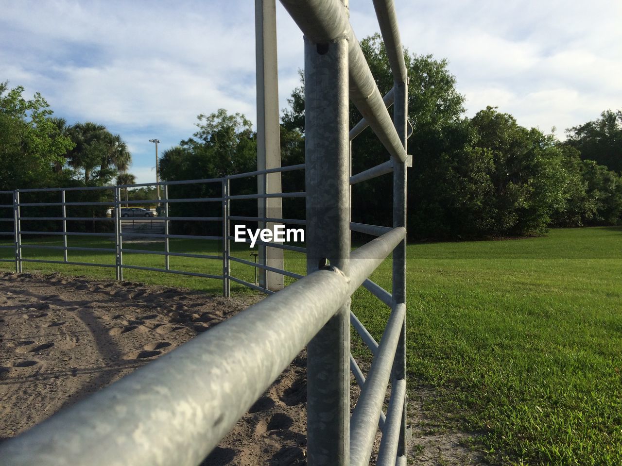 Metallic fence on field against sky