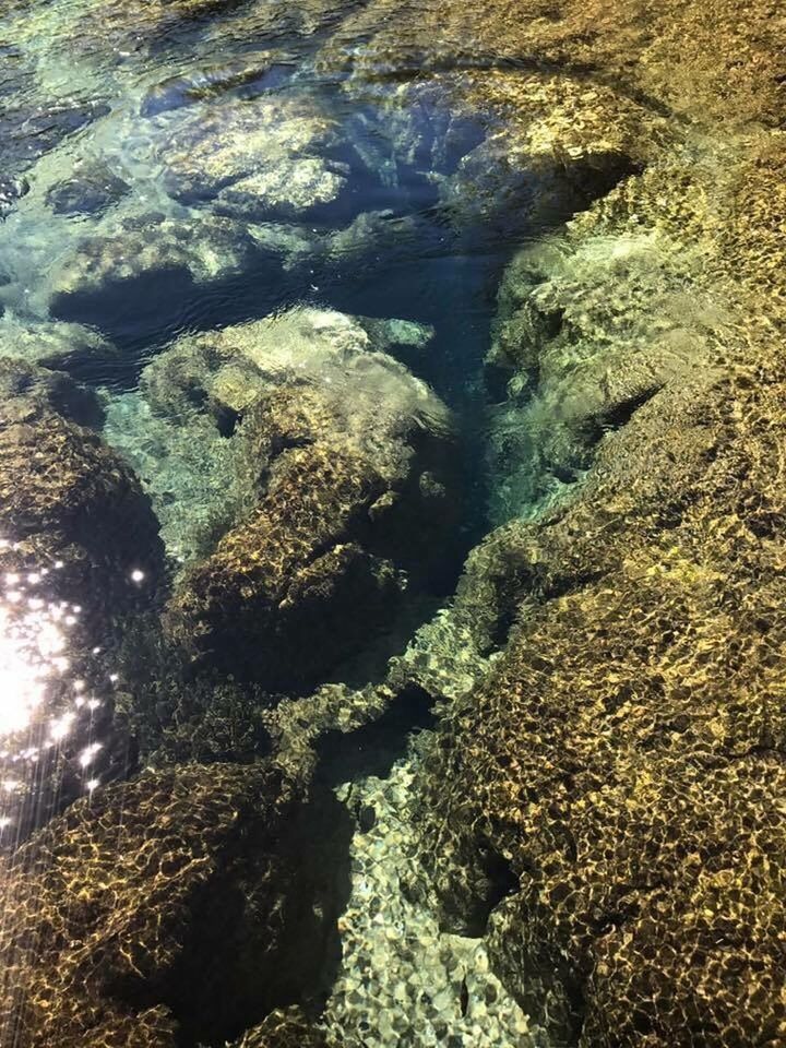 HIGH ANGLE VIEW OF WATER FLOWING IN ROCKS