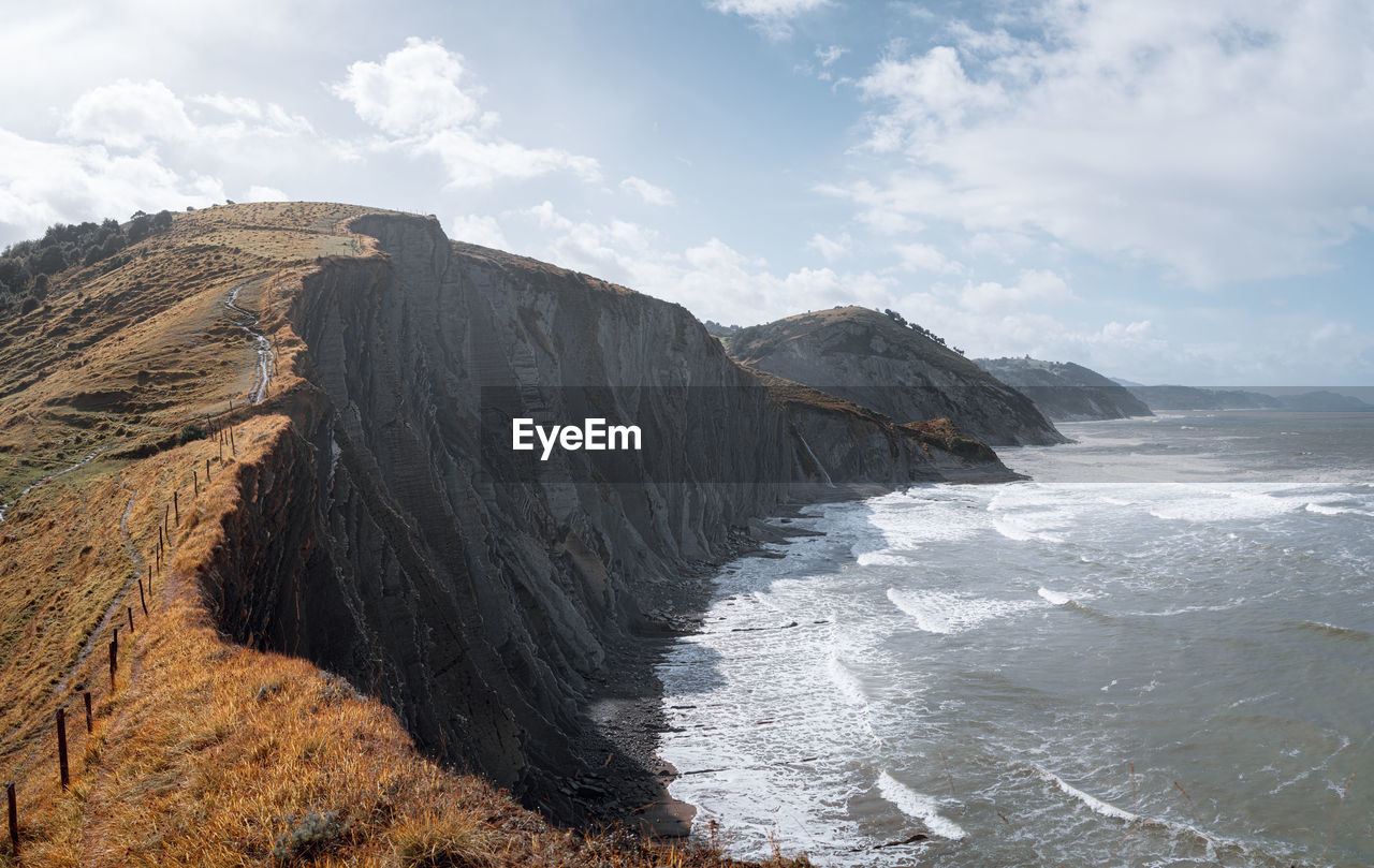 Scenic view of coast against sky