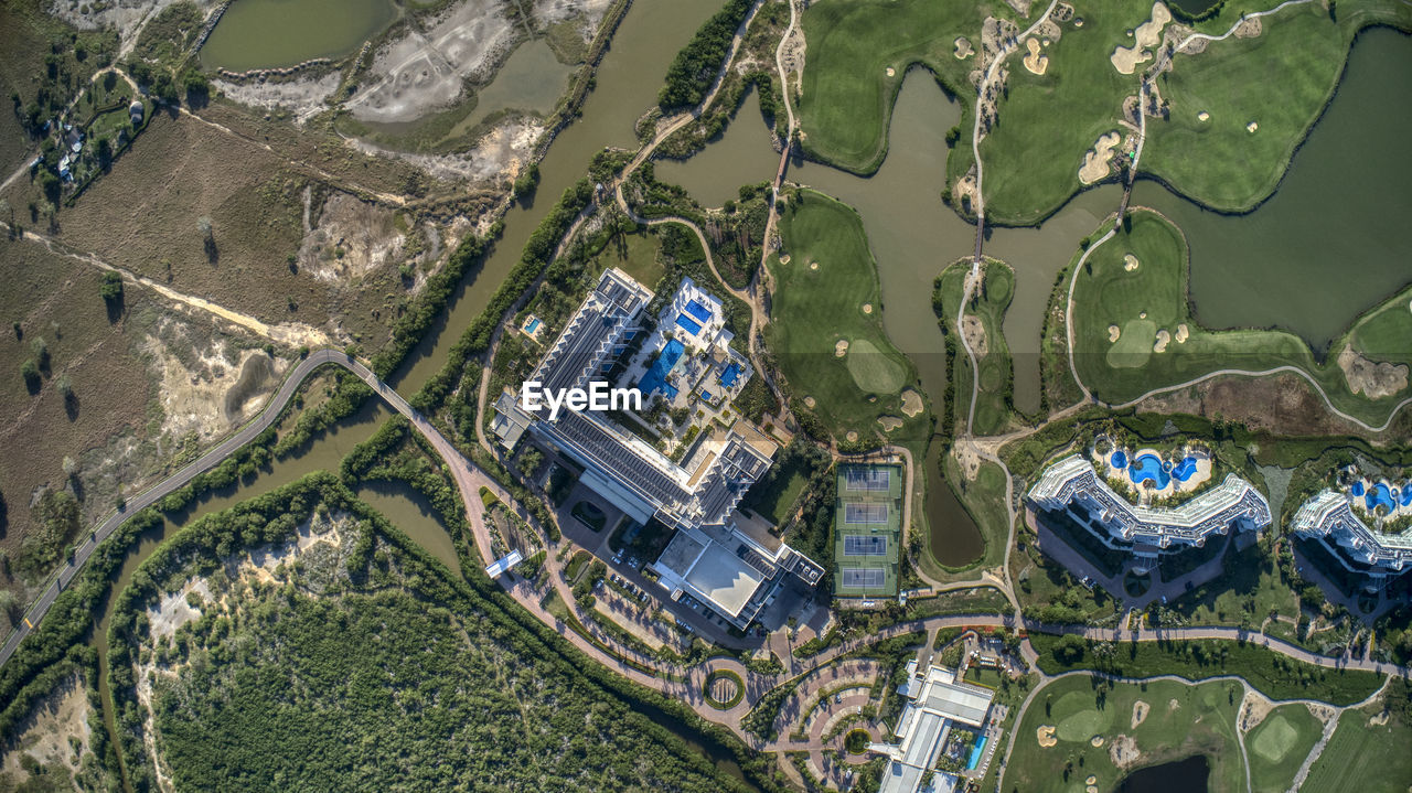 HIGH ANGLE VIEW OF BUILDING BY CANAL AGAINST TREES
