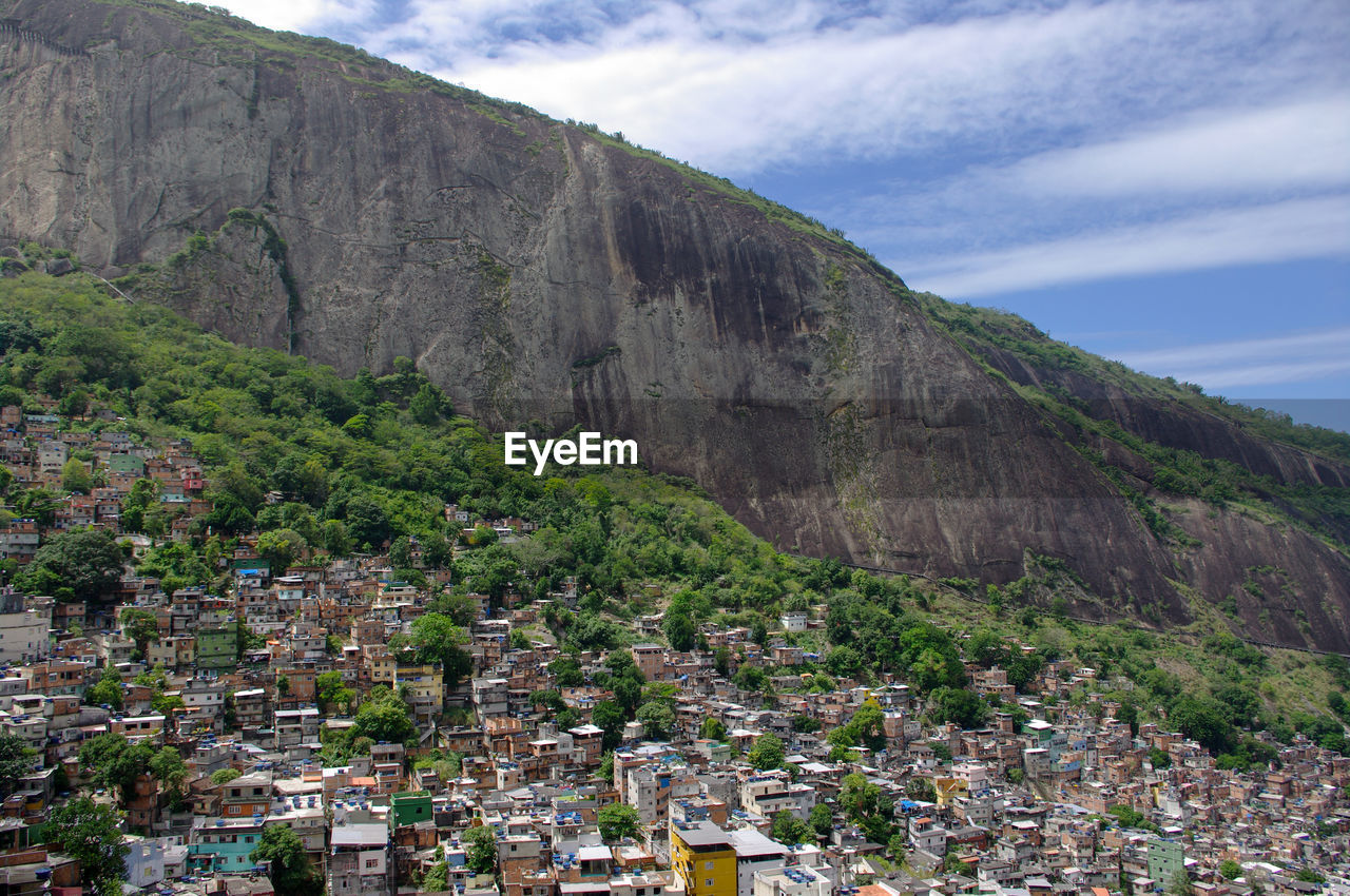 Houses by mountain against sky