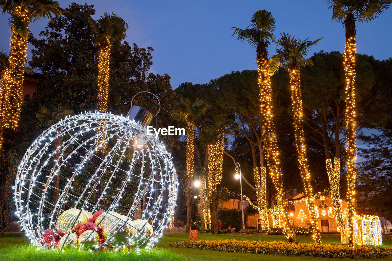 plant, tree, illuminated, night, nature, grass, celebration, decoration, christmas decoration, sky, christmas, park, christmas lights, arts culture and entertainment, architecture, holiday, no people, park - man made space, outdoors, event, amusement park, travel destinations, lighting equipment, amusement park ride, built structure