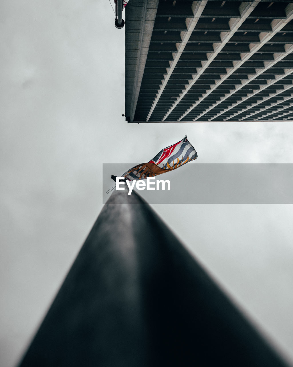 Low angle view of flag on roof against sky