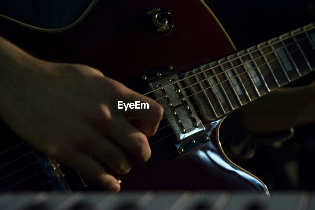 Close-up of hand plucking guitar