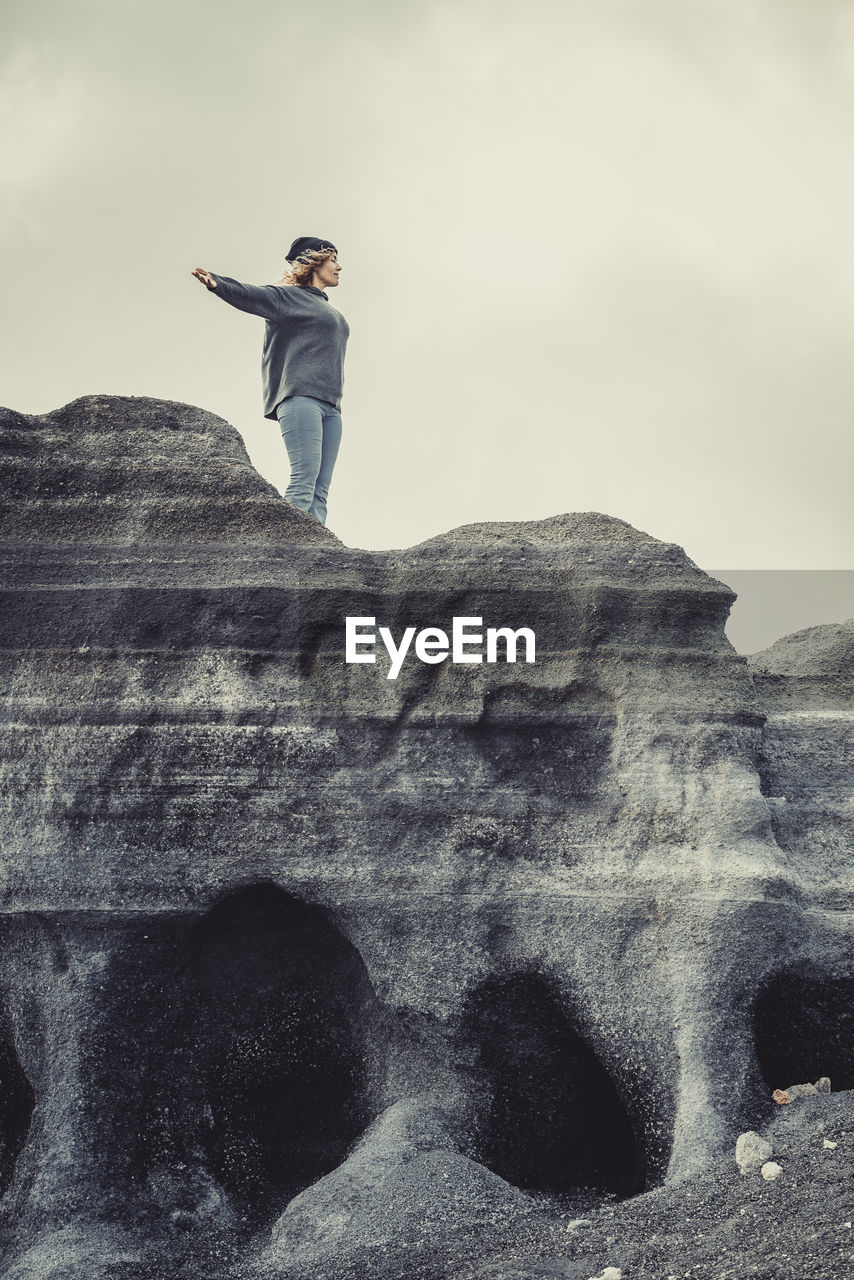 rear view of man standing on rock formation