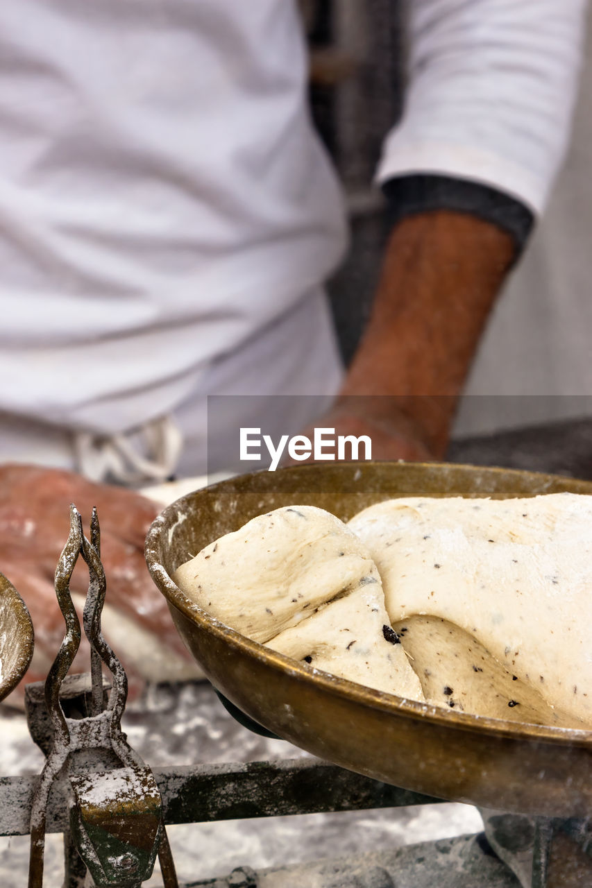 MIDSECTION OF MAN PREPARING FOOD IN TRAY