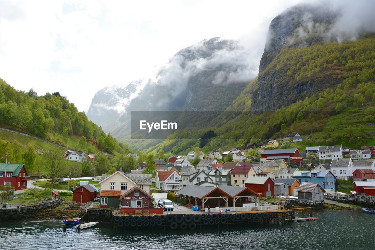 Scenic view of lake by buildings against mountains