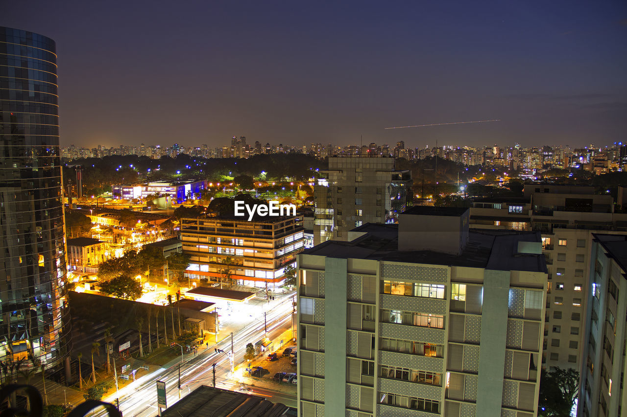 Illuminated buildings in city against sky at night