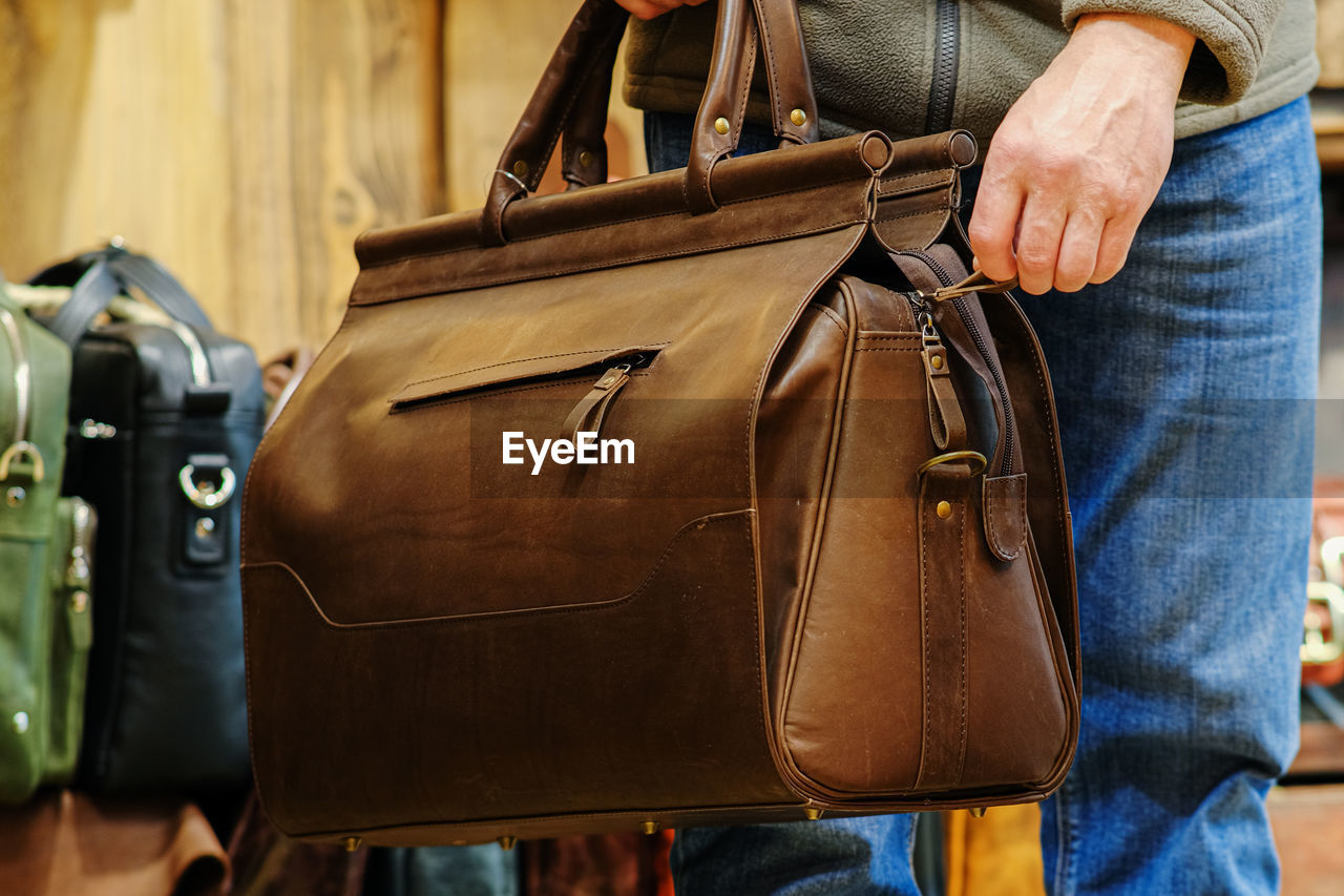 Midsection of man with bag at market stall