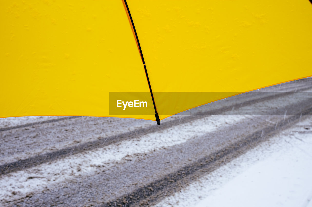 View under umbrella in front of snowy road