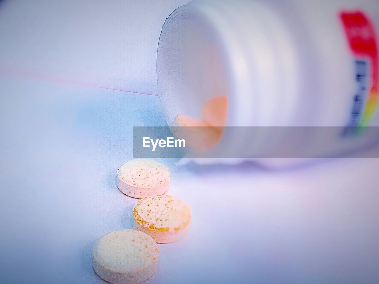 Close-up of pills and plastic bottle on table