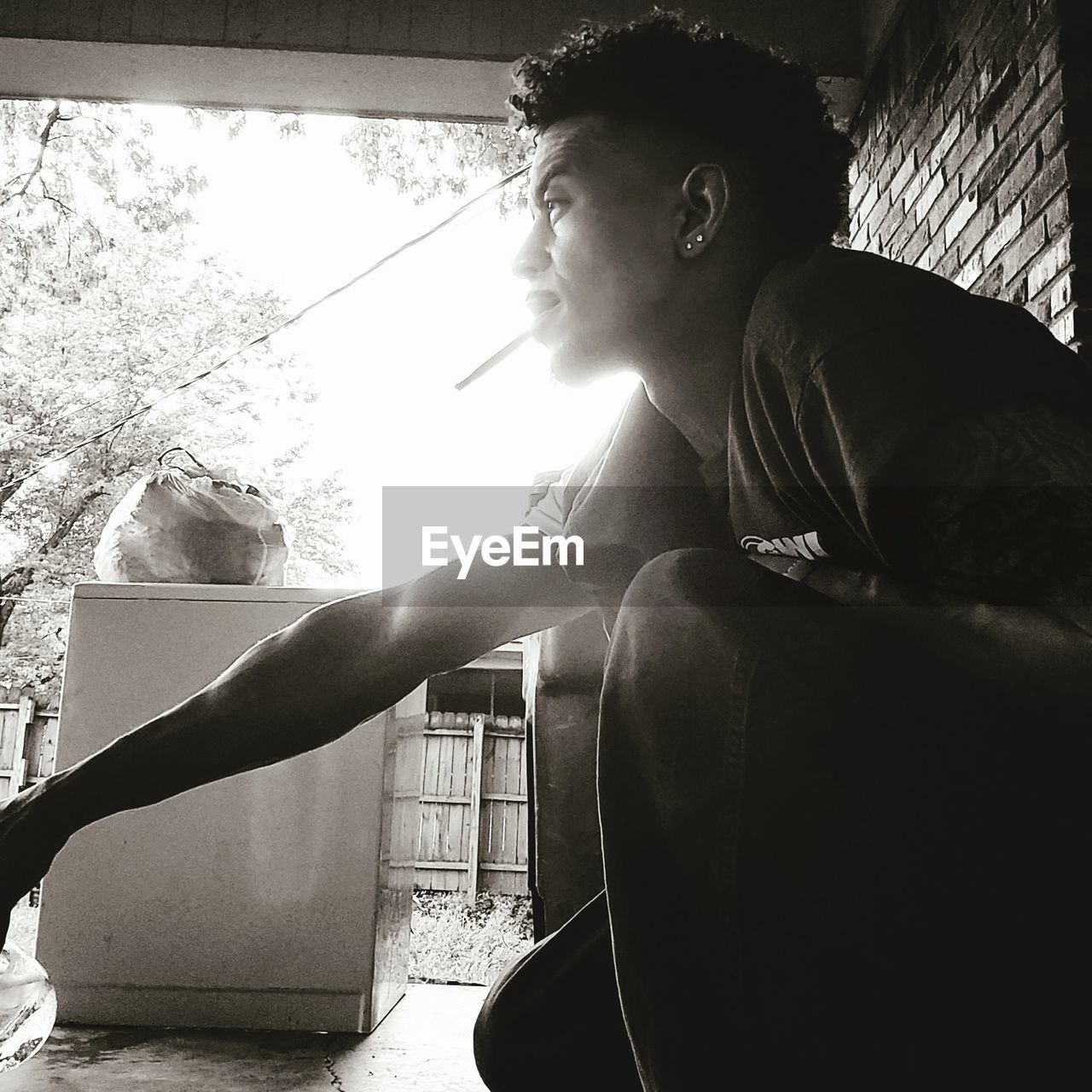black, one person, adult, black and white, white, lifestyles, young adult, monochrome, monochrome photography, sitting, sunlight, person, photo shoot, men, leisure activity, nature, day, side view, architecture, indoors, casual clothing, back lit, window, clothing