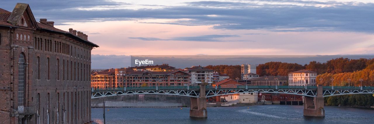 Bridge over river against buildings in city