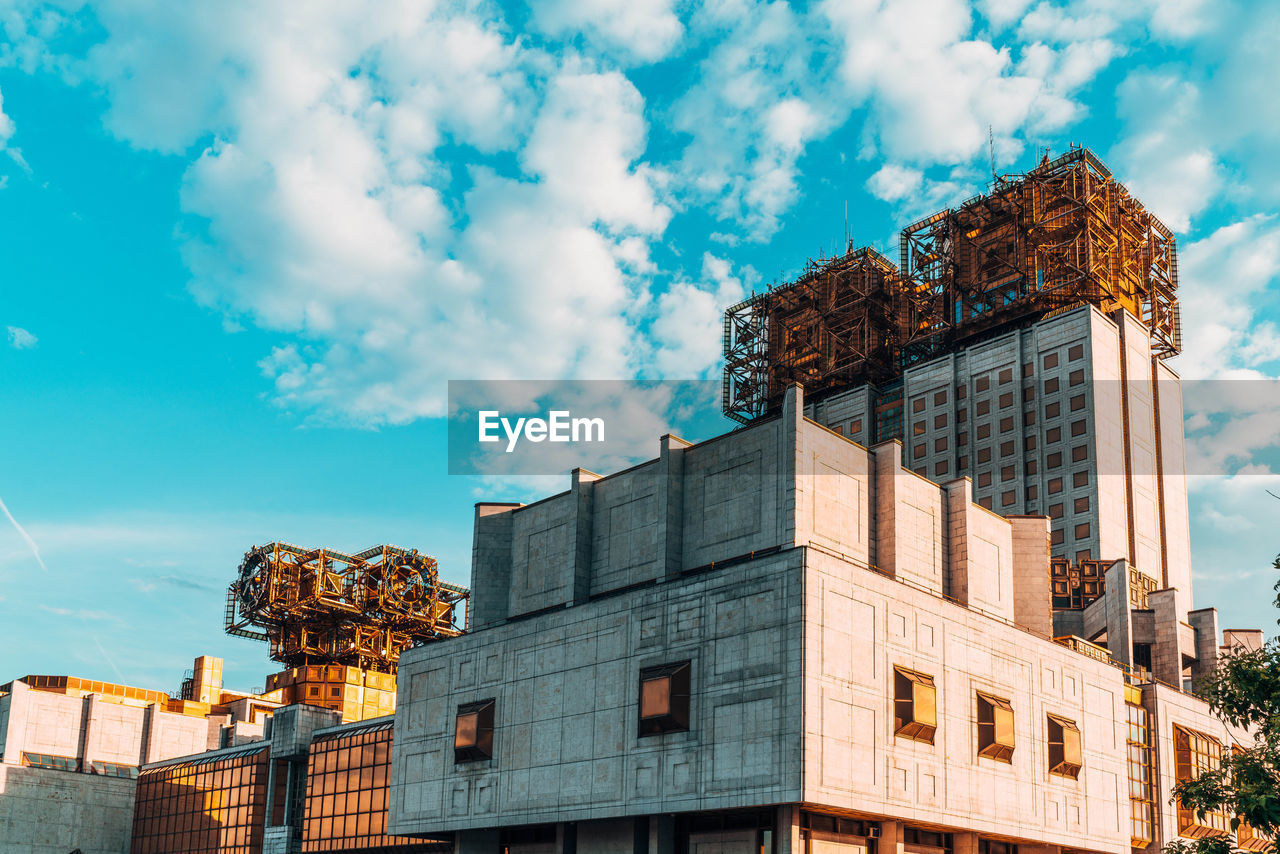 LOW ANGLE VIEW OF BUILDINGS AGAINST CLOUDY SKY