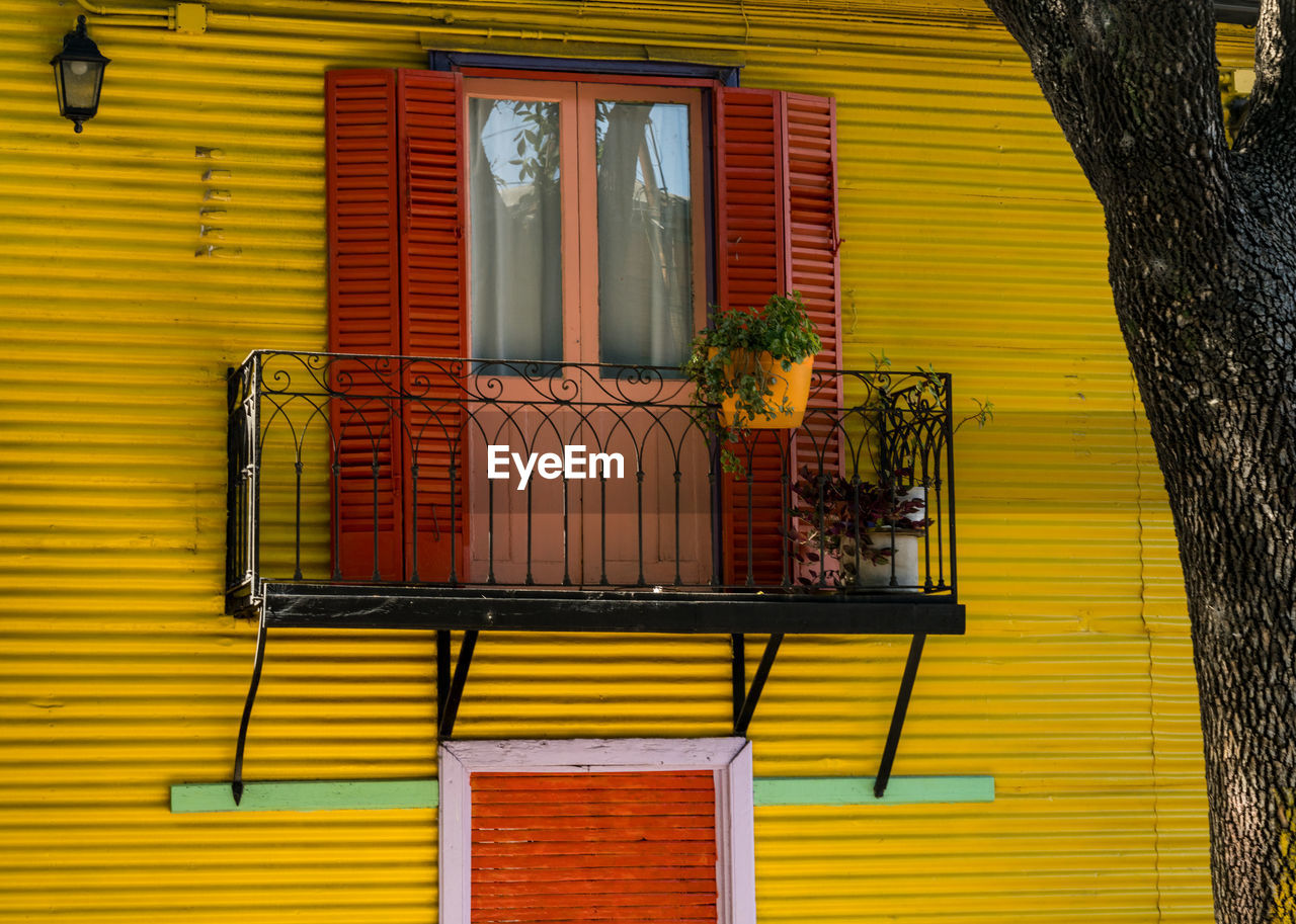 yellow, architecture, building exterior, built structure, house, window, window covering, shutter, interior design, wood, building, no people, facade, wall, day, residential district, home, wall - building feature, closed, outdoors, window blind, door