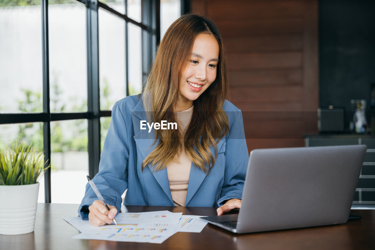 portrait of young businesswoman using laptop at table