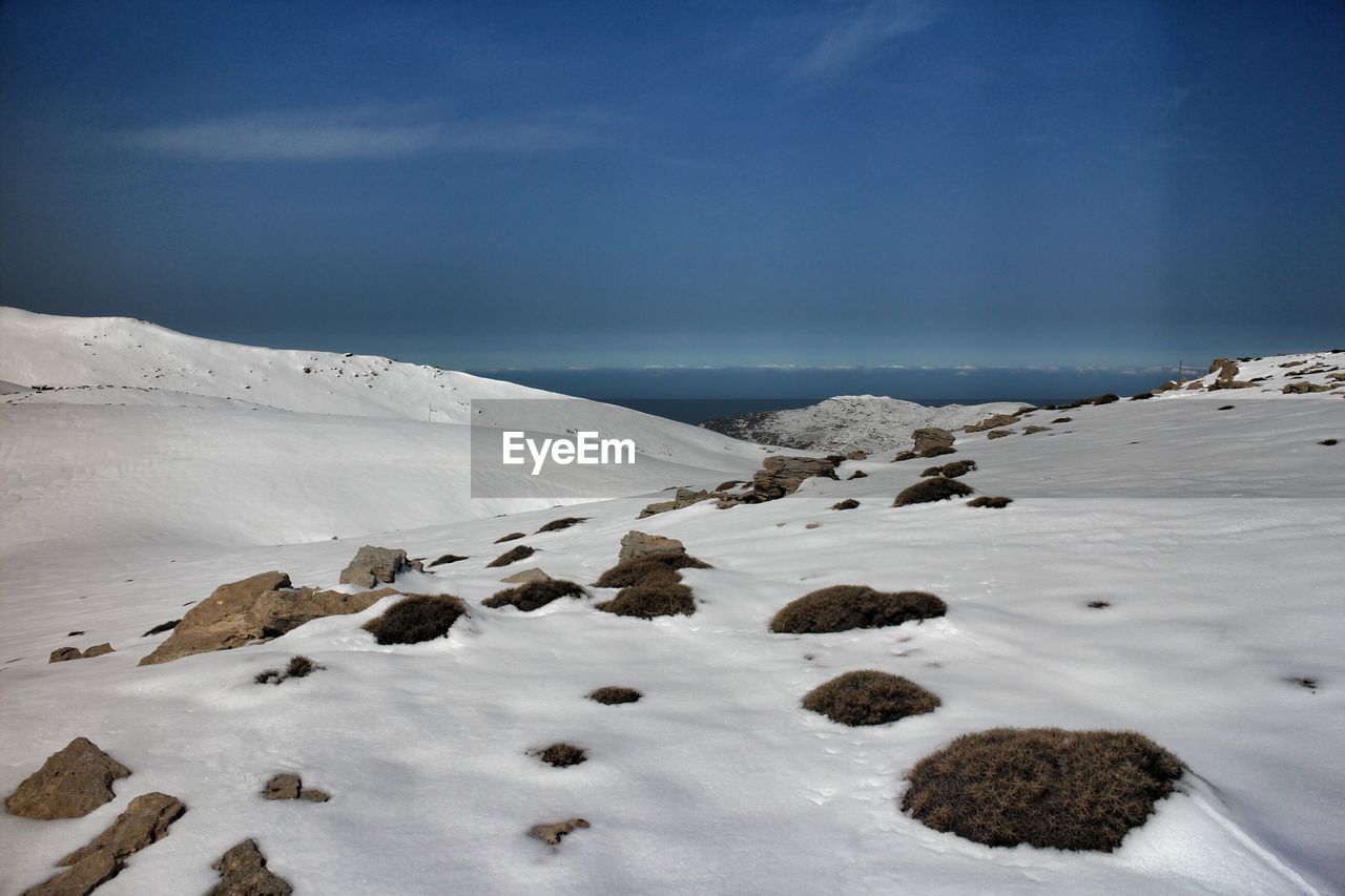 Snowy landscape against blue sky