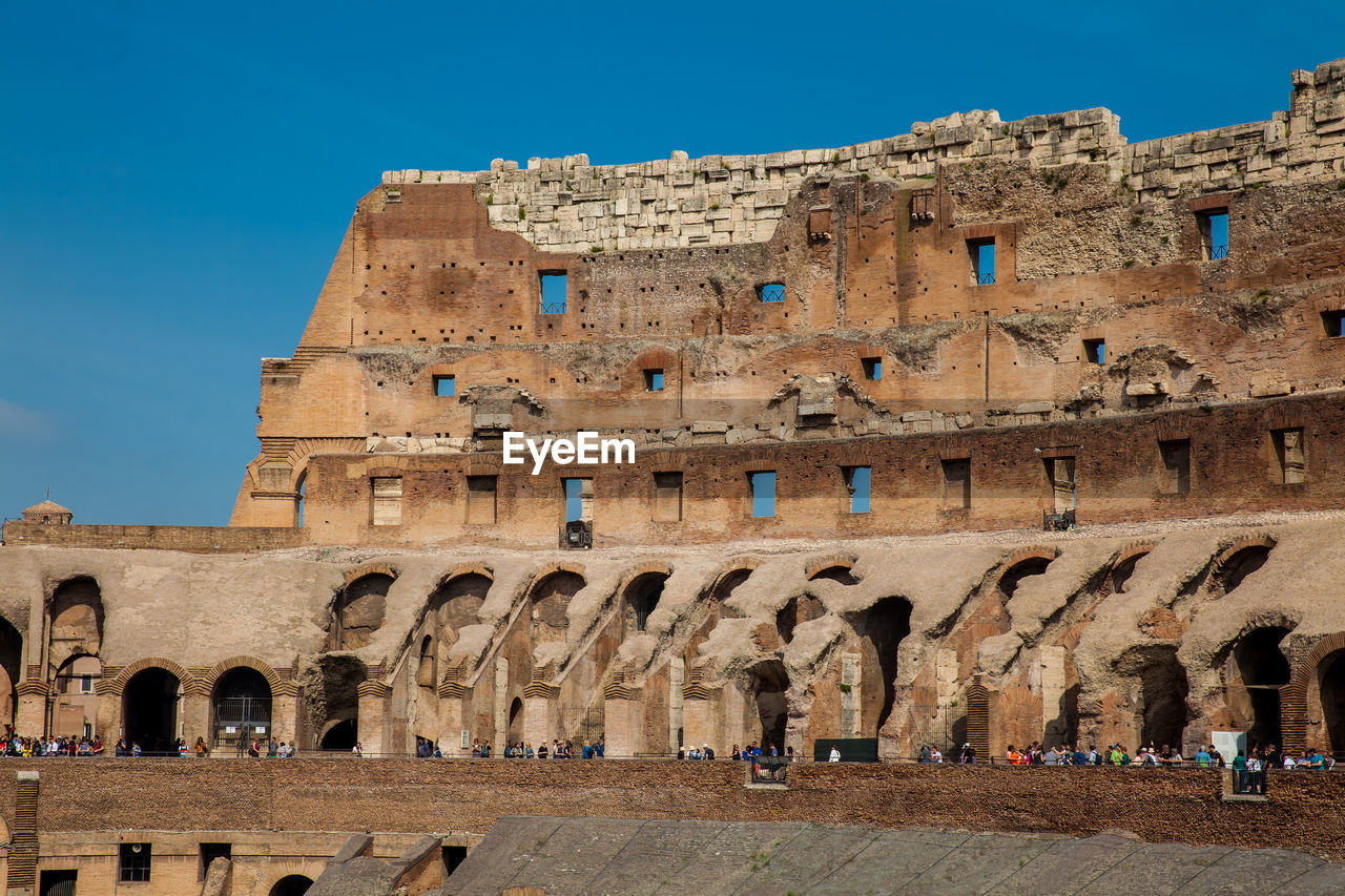 Tourists visiting the interior of the famous colosseum in rome