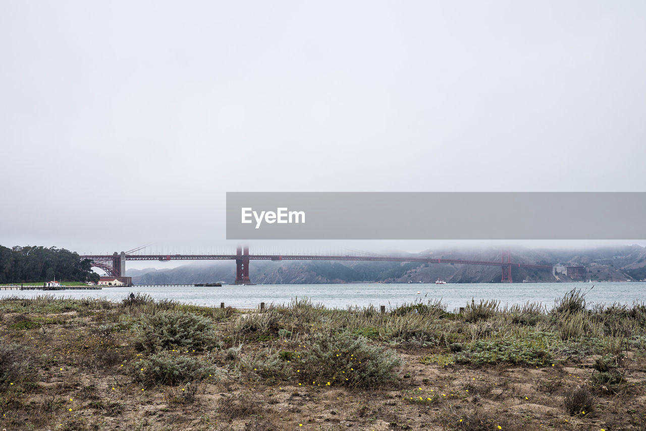 Scenic view of golden gate bridge over bay in clouds