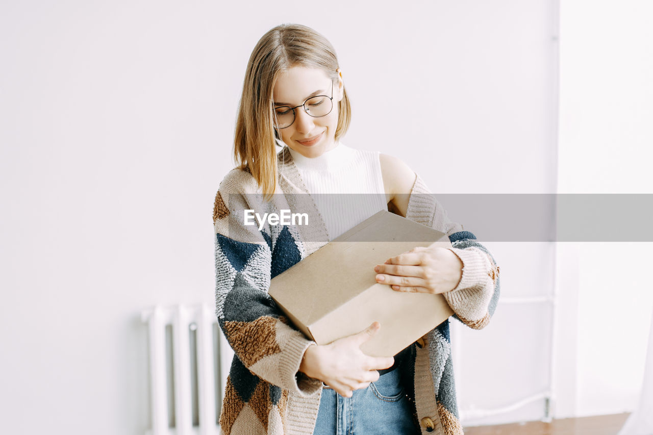 A girl receives a parcel from a courier, delivery, order, box, online shopping, millennial, hipster, 