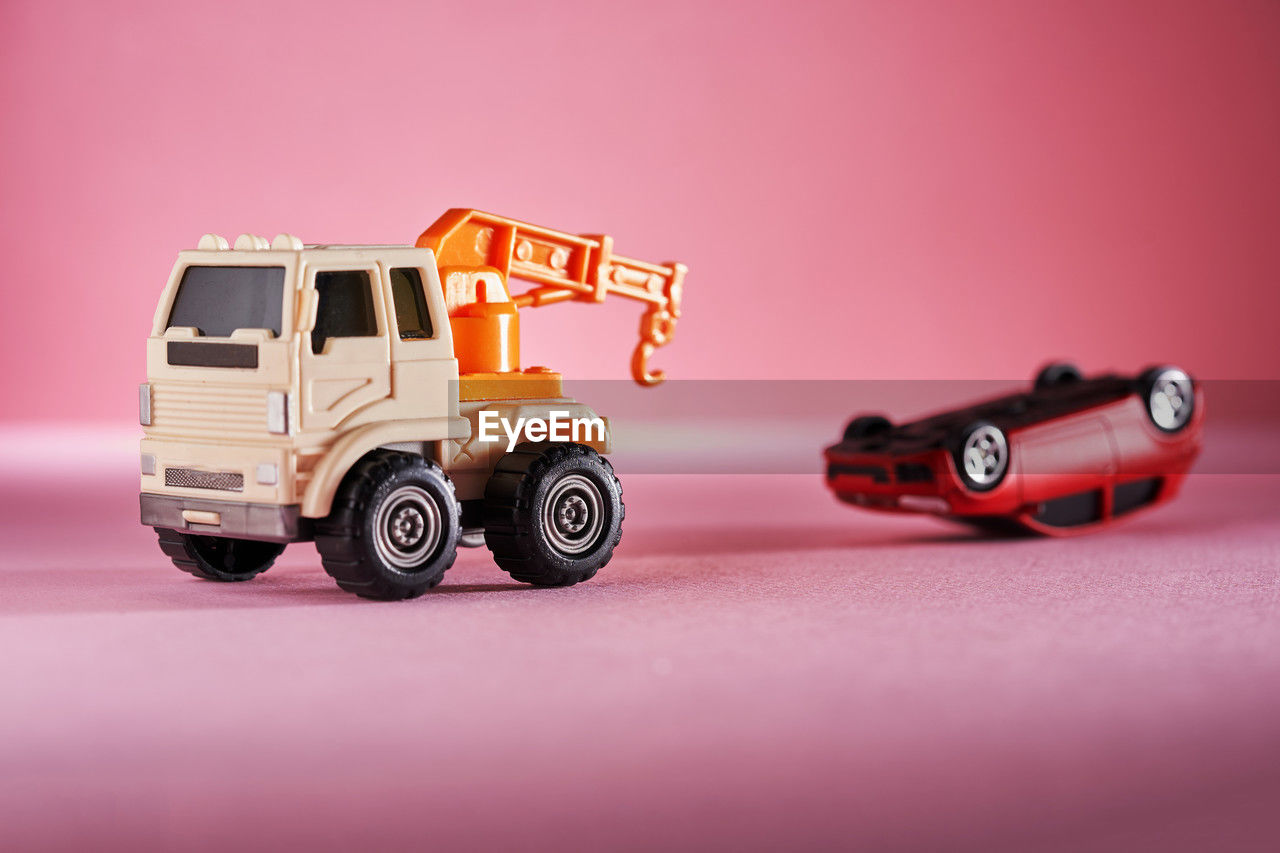 transportation, vehicle, mode of transportation, car, colored background, motor vehicle, toy, land vehicle, studio shot, toy car, truck, wheel, no people, red, copy space, pink, indoors, model car