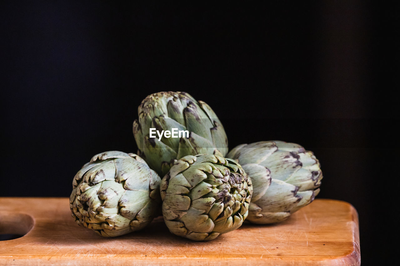 Still life of artichokes on a wooden board