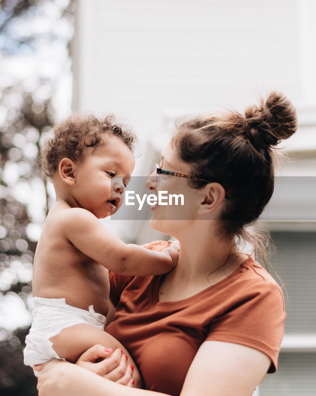 Mother embracing son sitting at home