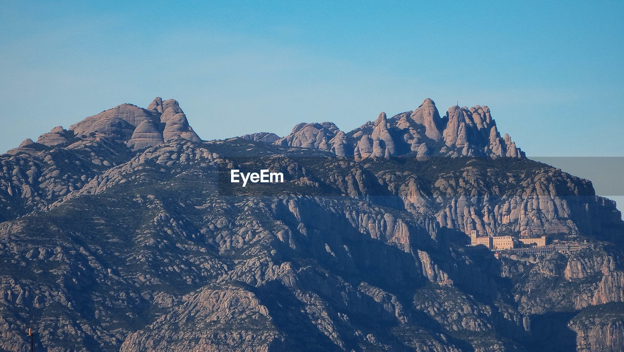 Panoramic view of rocky mountains against clear sky