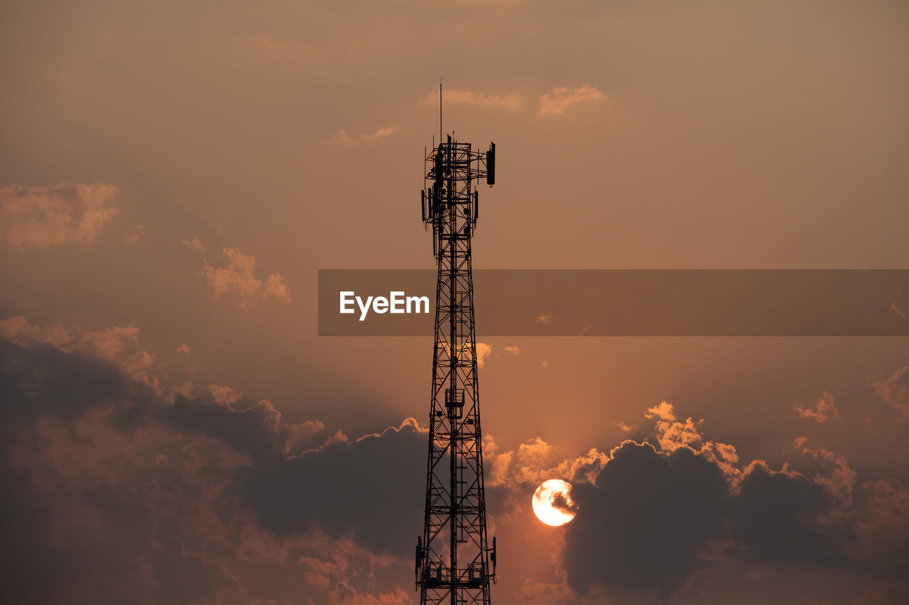LOW ANGLE VIEW OF COMMUNICATIONS TOWER AGAINST CLOUDY SKY