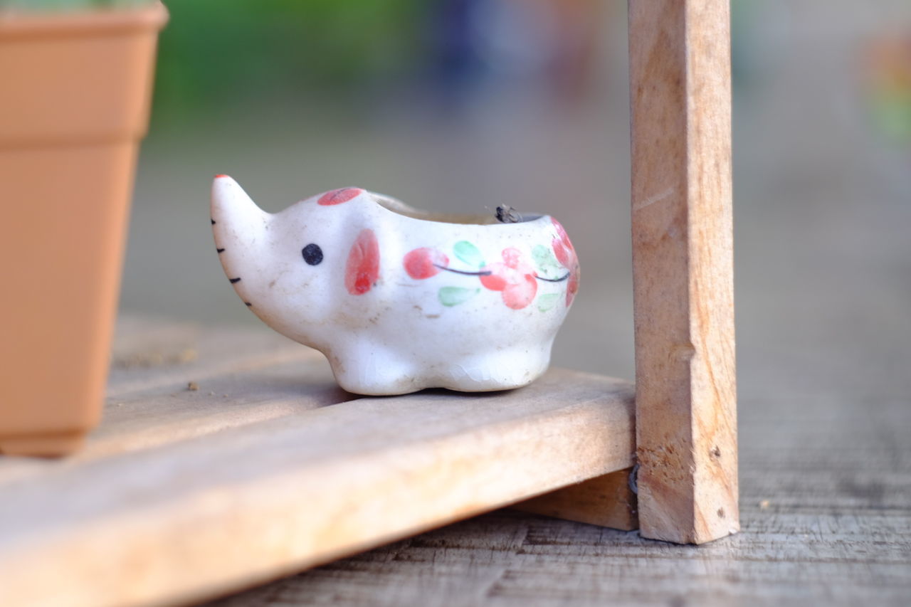 Close-up of ceramic elephant by potted plant