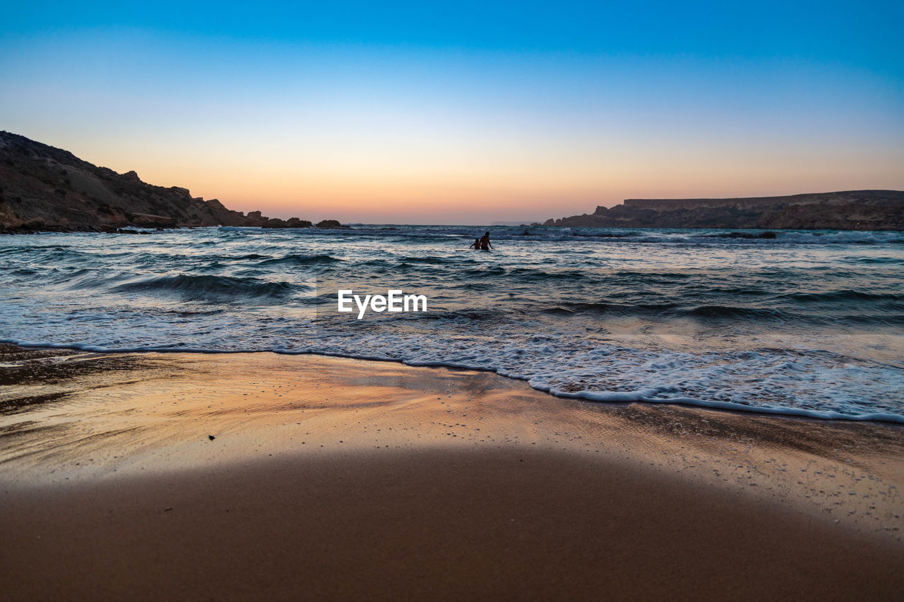 SCENIC VIEW OF BEACH DURING SUNSET