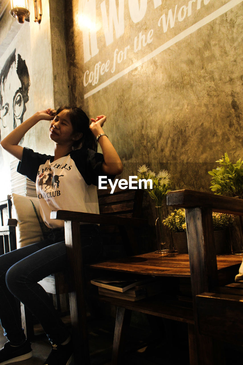 Woman sitting on seat in restaurant