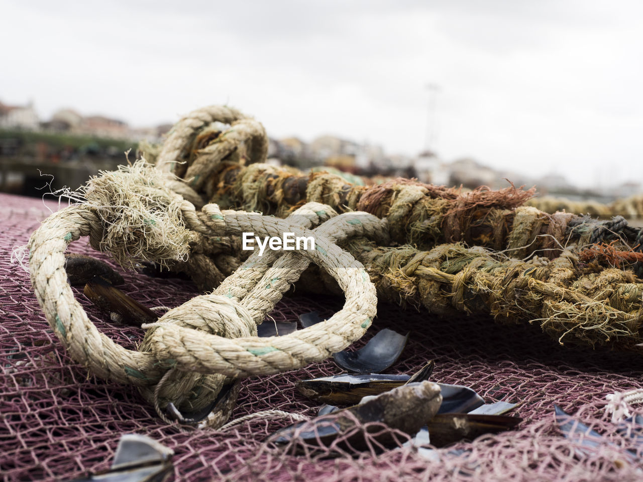 Close-up of weathered rope tied to fishing net