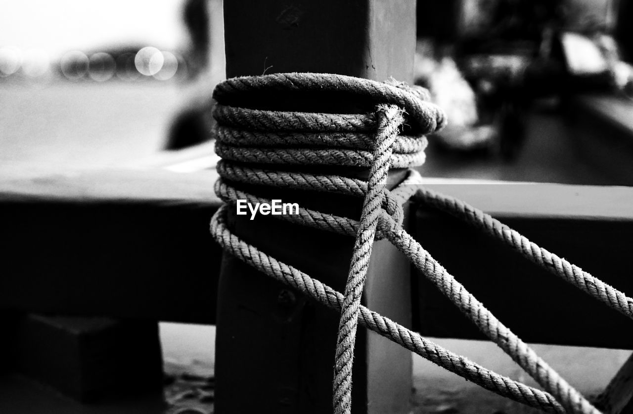 CLOSE-UP OF ROPES TIED ON WOODEN POST