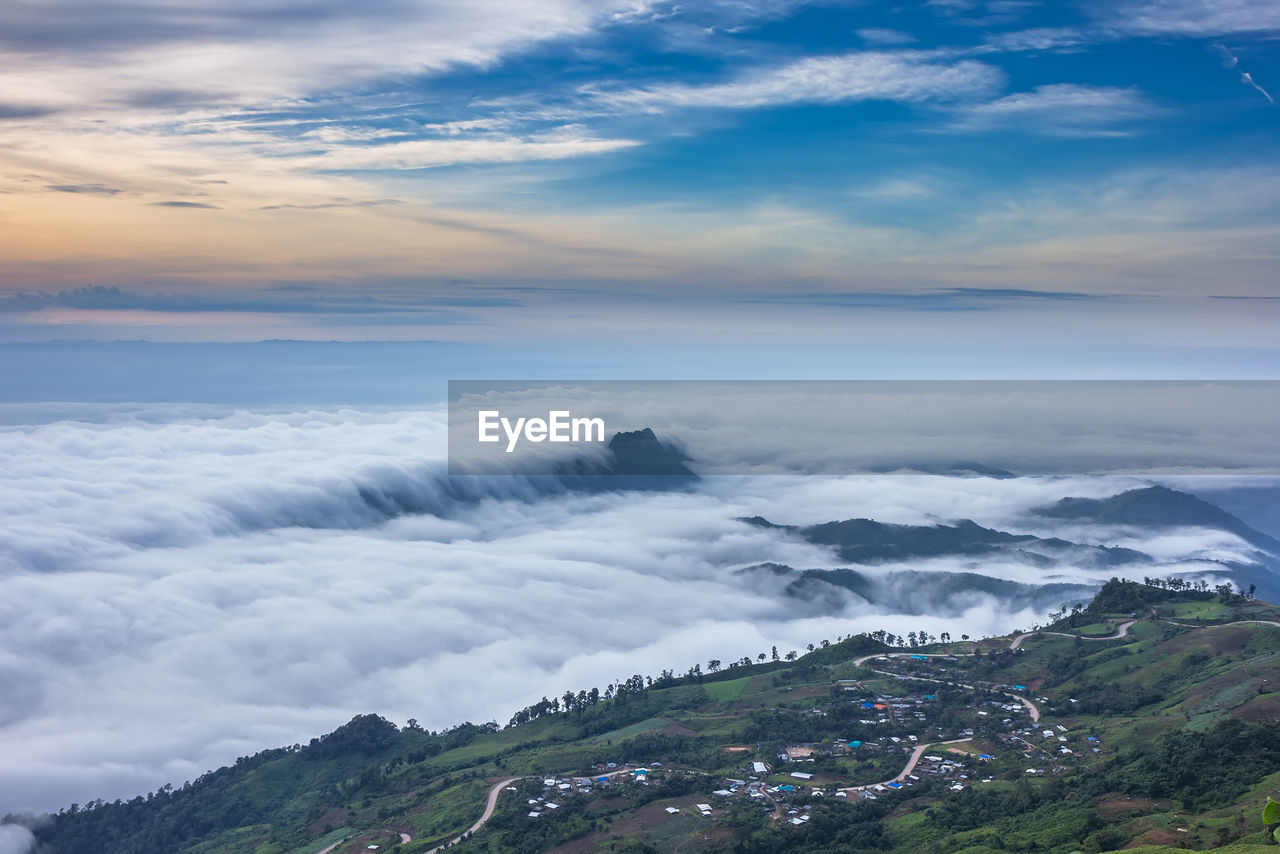 Scenic view of mountains against cloudy sky during sunset