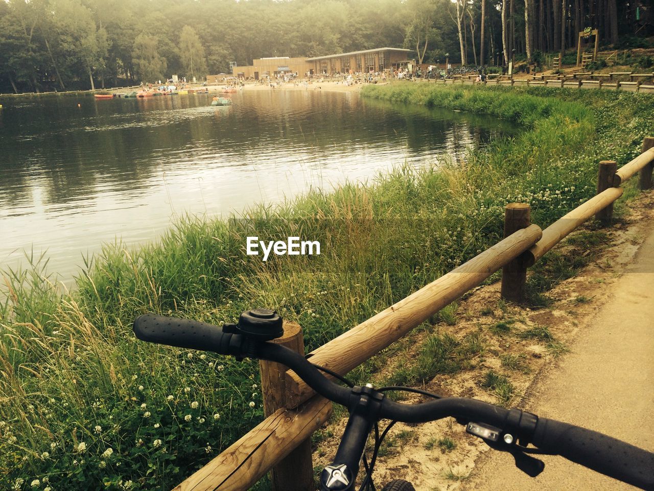 Cropped image of bicycle on road by lake