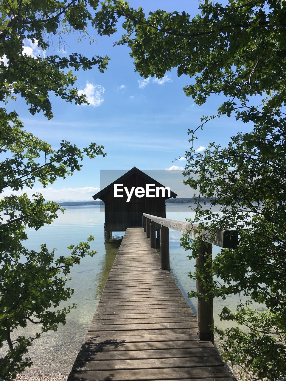 Pier amidst trees and building against sky