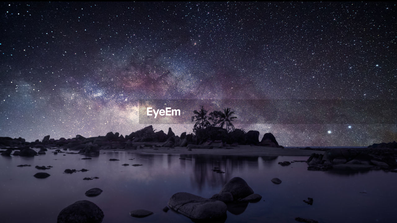 Scenic view of lake against sky at night