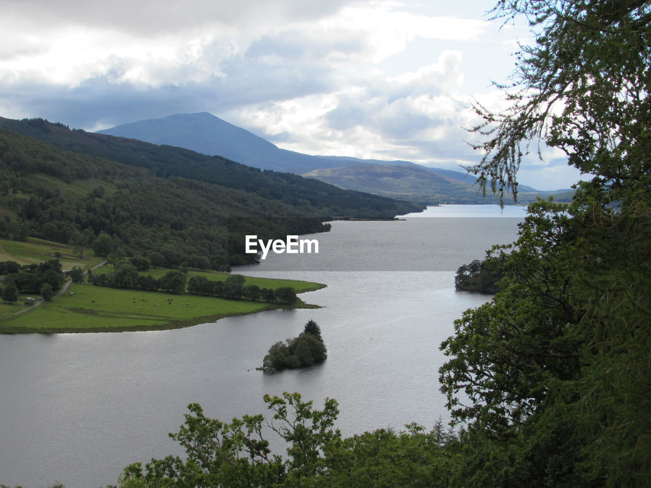 SCENIC VIEW OF LAKE AND MOUNTAINS AGAINST CLOUDY SKY