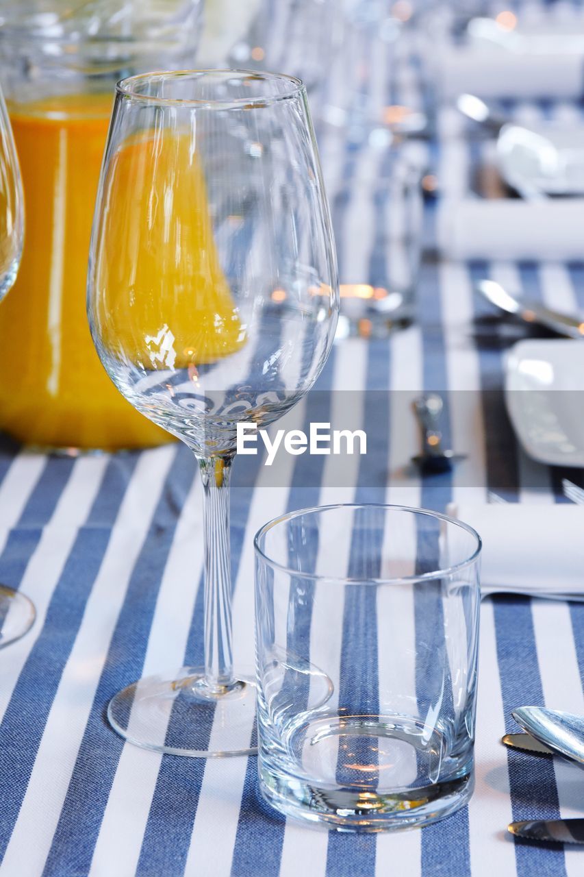 Close-up of empty wineglass and drinking glass on table